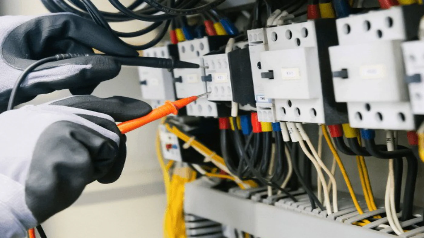 Teknisyenin elektrik panosunda ölçü aletiyle ölçüm yapması