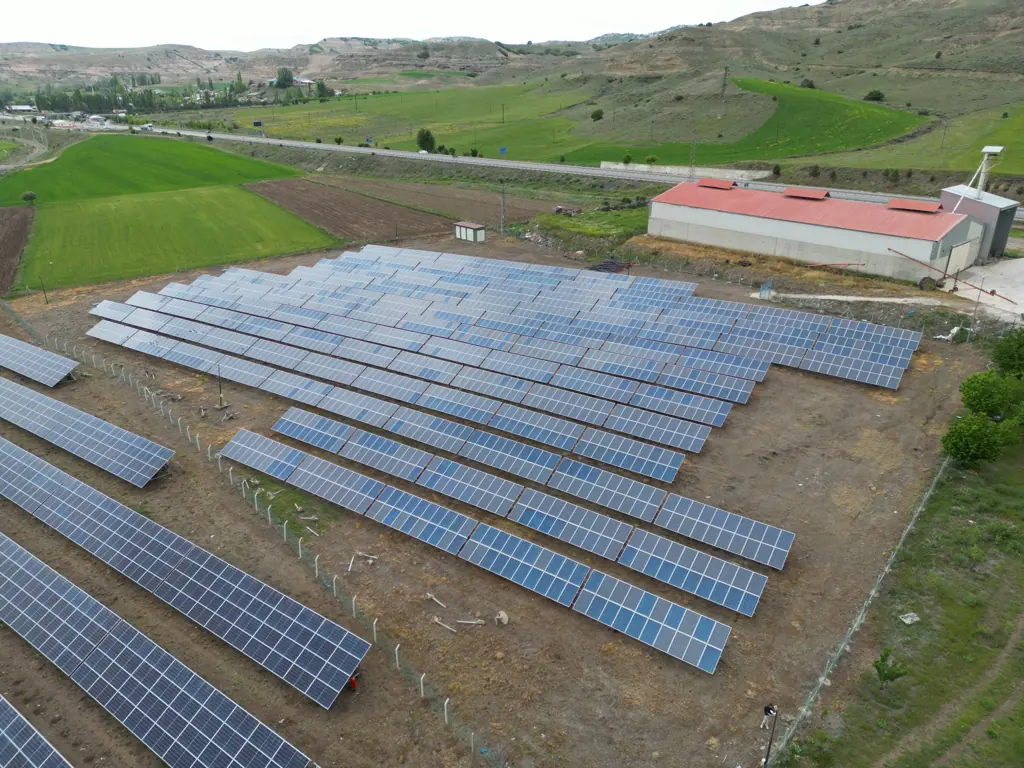 Arazi GES panel sıraları ve trafo köşkü, havadan yakın görünüm